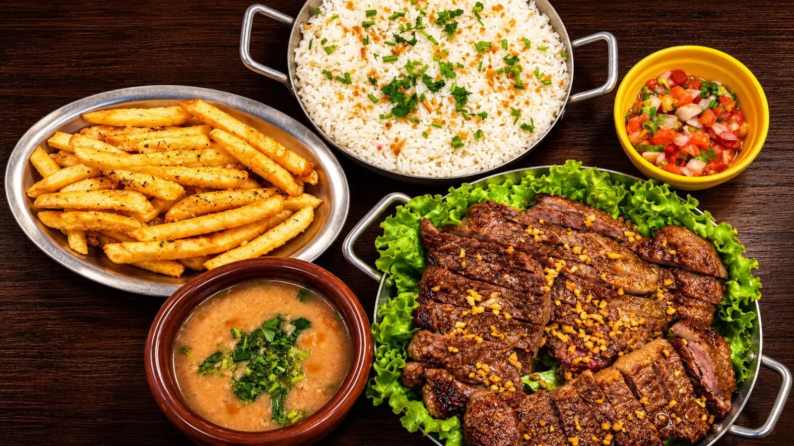 Carne fatiada com alho frito, arroz, batata frita, vinagrete e caldo de feijão, prato para dividir