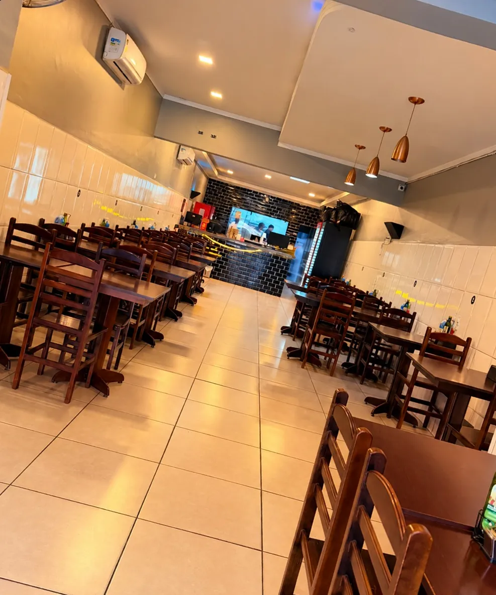 Salão do Panelão da Vila Grill, com mesas de madeira